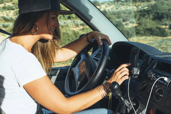 Turuncu şapkalı hoş sarışın kadın. Sarı şapkalı, turuncu minibüslü sarışın kadın. GPS 'i kontrol ediyor.