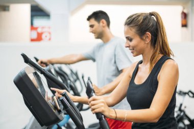 Yetişkin çift sağlıklı yaşam tarzı konsepti için fitness jimnastik salonunda Step tırmanma makinesinde çalışıyor..