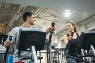 Yetişkin çift sağlıklı yaşam tarzı konsepti için fitness jimnastik salonunda Step tırmanma makinesinde çalışıyor..