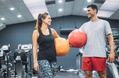 Spor salonunda elinde ilaç topu olan orta yaşlı bir çift.