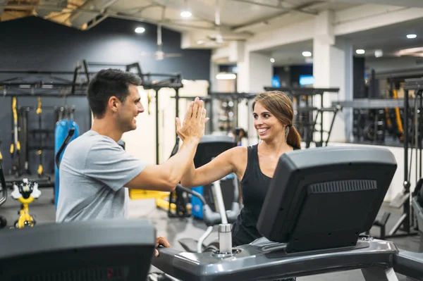 Yetişkin bir çift spor salonunda koşu bandında koşuyor.