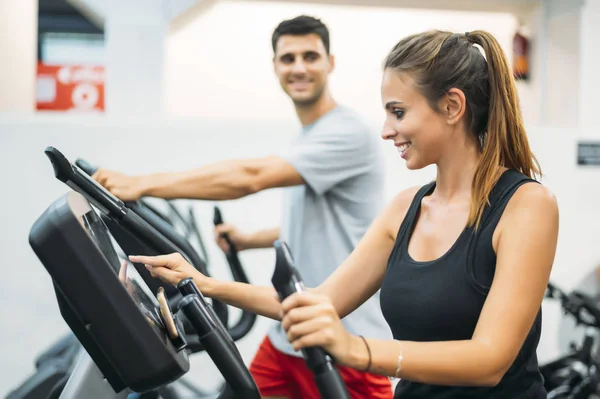 Adult couple is working out on Step climber machine in fitness gym for healthy lifestyle concept.