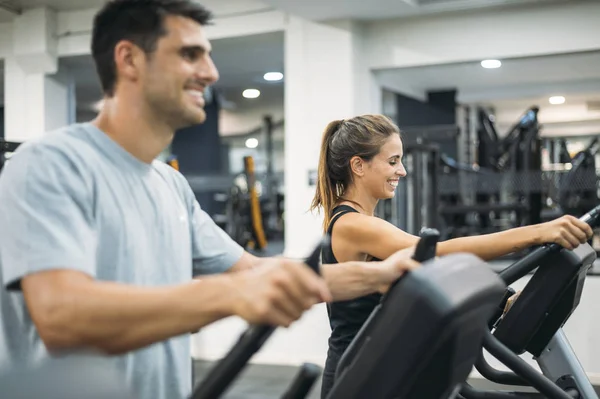 Dospělý pár je cvičení na krok horolezec stroj ve fitness tělocvičně pro zdravý životní styl koncept. — Stock fotografie