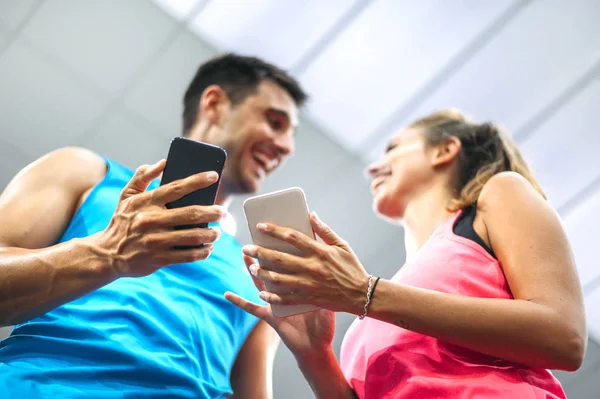 Middle-aged couple with the phone in gym — Stock Photo, Image