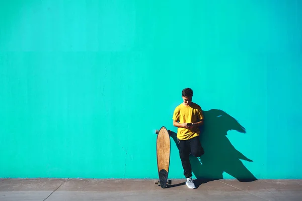 カラフルな通りでスケートボードと若いの肖像画 — ストック写真