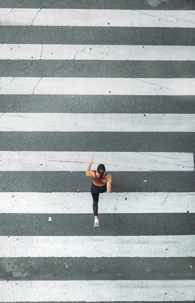 Uma mulher correndo para a travessia de zebra — Fotografia de Stock