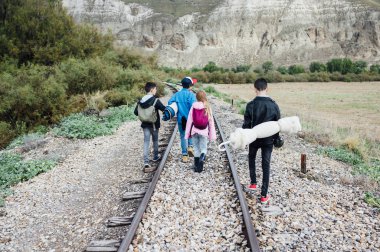 Ormanda yürüyüş yapan dört çocuktan oluşan bir grup tren yolunda yürüyor.
