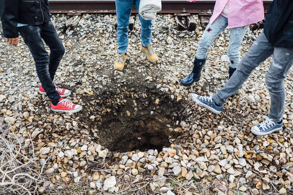 Grupo de quatro crianças que estão a entupir o buraco — Fotografia de Stock