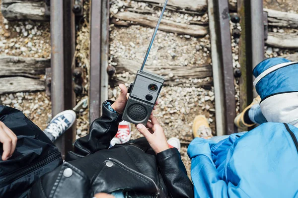 Crianças pequenas irreconhecíveis usando um walkie-talkie em pé em trilhos de trem — Fotografia de Stock