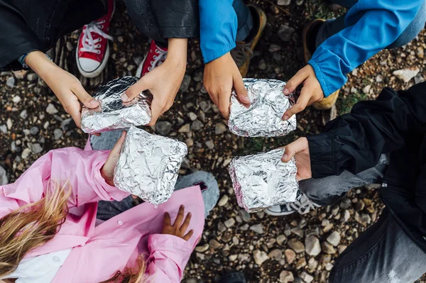 De kinderen met een broodje verpakt in zilverpapier — Stockfoto