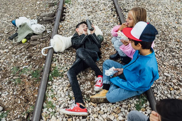 Ομάδα από τέσσερα παιδιά ευτυχισμένα σε μια σιδηροδρομική γραμμή — Φωτογραφία Αρχείου