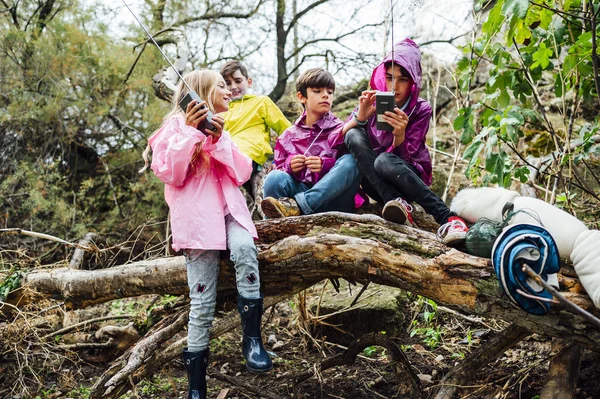 Νεαροί φίλοι παιδιά που χρησιμοποιούν γουόκι-τόκι και στέκονται στο δάσος — Φωτογραφία Αρχείου