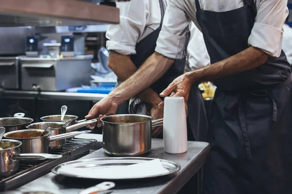 Chef irreconocible cocinando comida en una cocina de restaurante — Foto de Stock