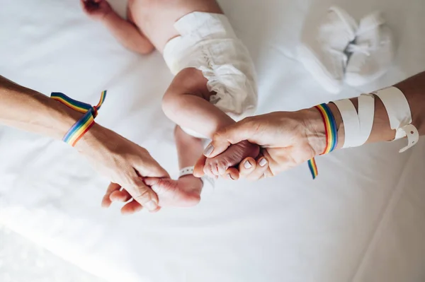 Dos mujeres unieron sus manos con orgullo de pulso y un bebé en el hospital —  Fotos de Stock