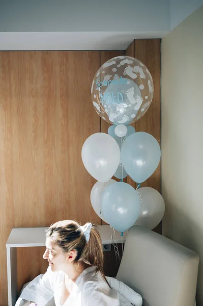 Vrouw die bevallen is in een ziekenhuiskamer met blauwe ballonnen — Stockfoto