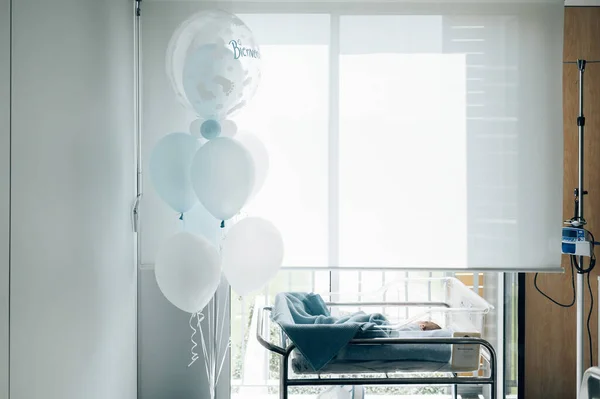 Cama de hospital para un recién nacido con globos azules —  Fotos de Stock