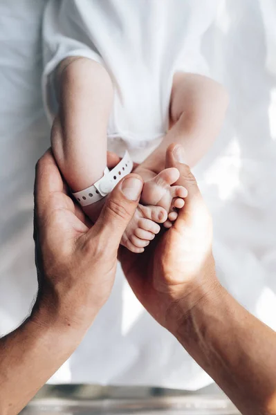 병원에서 갓 태어난 아기 의발에 손을 대는 아버지 — 스톡 사진