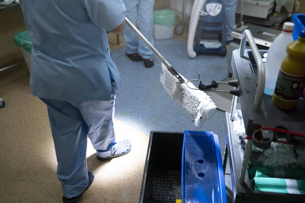 Mulher irreconhecível limpando a sala de cirurgia — Fotografia de Stock