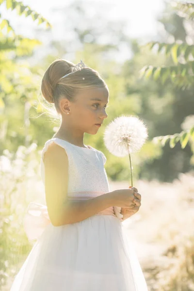 Aantrekkelijk blond meisje in het veld gekleed in communie — Stockfoto