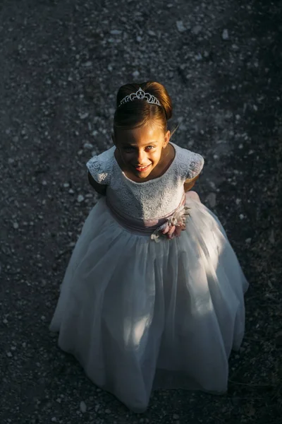 Beyaz elbiseli şirin küçük kız portresi ve ilk kutsal komünyonda çelenk. — Stok fotoğraf