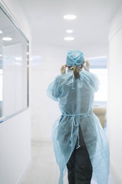 Kadın doktor hastane koridorunda yürüyor.