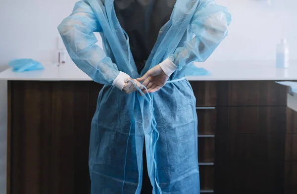 Kvinnlig läkare som tar på sig morgonrocken — Stockfoto