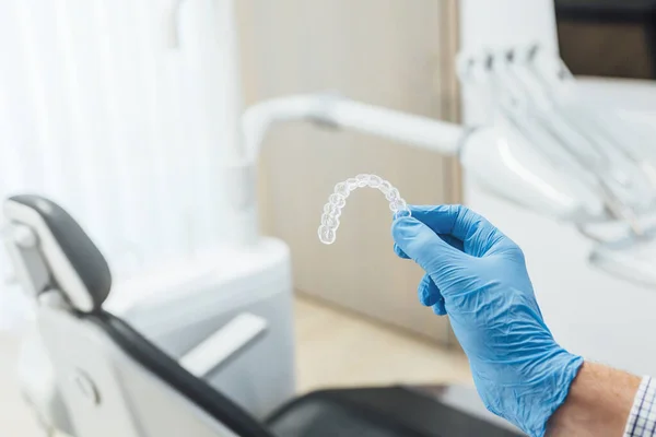 Médico mão segurando um aligner dental claro — Fotografia de Stock