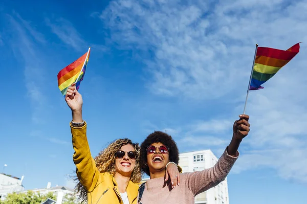 Two women friends hanging out in the city waving LGBT — ストック写真