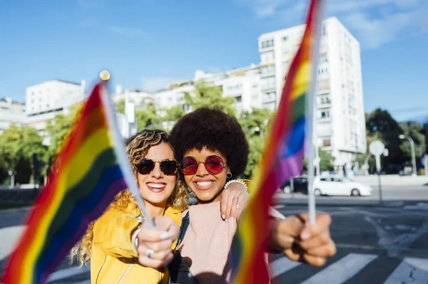 Duas mulheres amigas saindo na cidade acenando LGBT — Fotografia de Stock