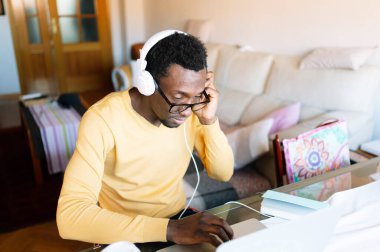Akıllı telefonu ve dizüstü bilgisayarı olan Afro adam evde.