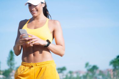 Atletik kadın akıllı telefonunu kullanıyor.