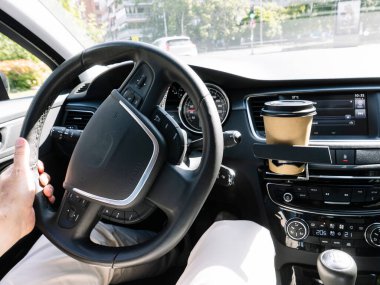 Bir arabanın içindeki bardak tutacağının içine bir kahve içeceği..