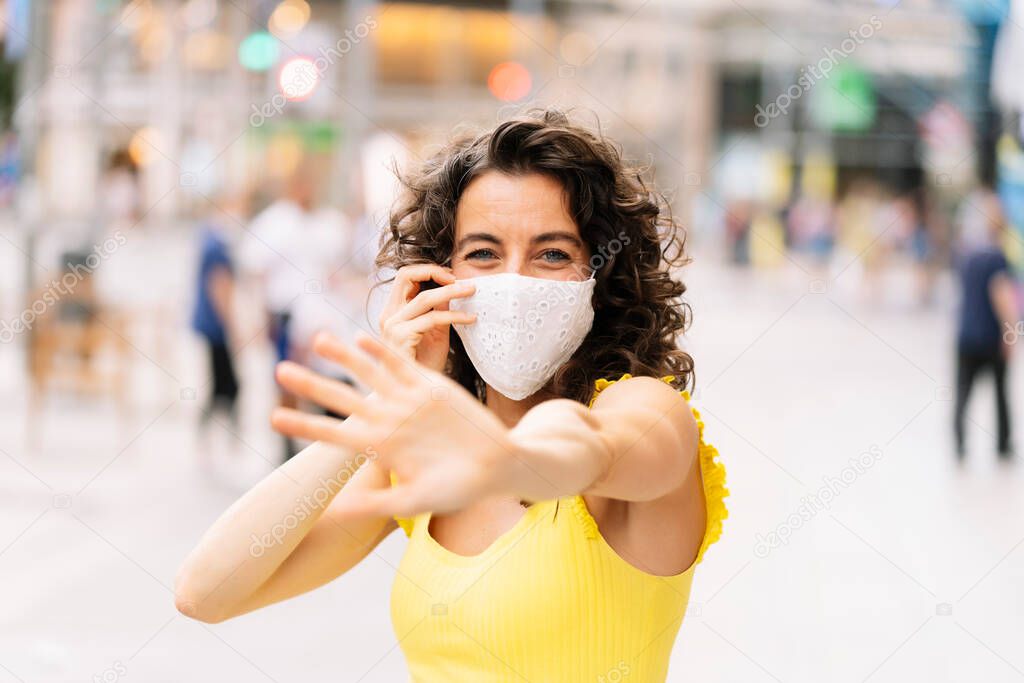 Brunette woman with a facial mask in the city