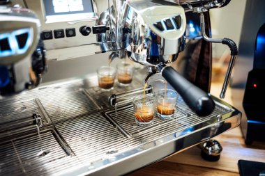 Kahve makinesi bardağa taze espresso yapıyor.