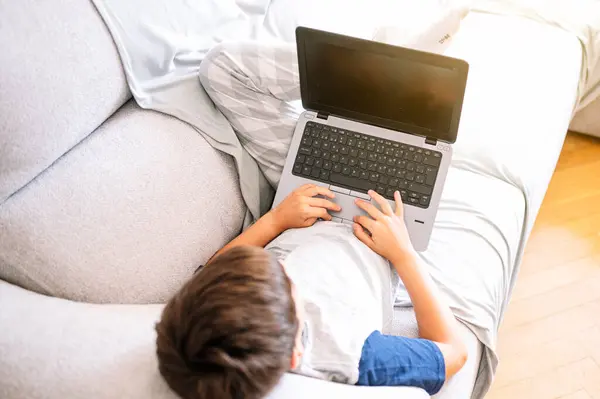 11 year old boy with laptop at home