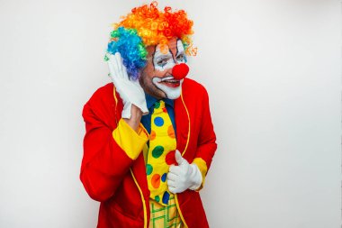 Palyaço kulaktan kulağa dinliyor.