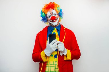 Palyaçonun elinde akıllı telefon ve aptal bir gülümseme