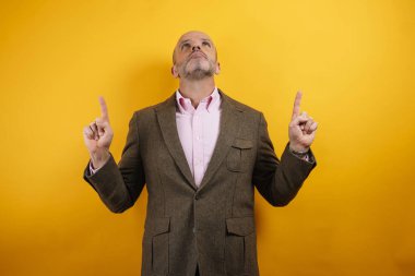 İki işaret parmağıyla gökyüzünü gösteren bir adam..