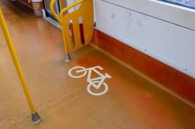 Turuncu zemini ve sarı yapıları olan modern bir metro treninin içindeki bisiklet park alanının ayrıntıları..
