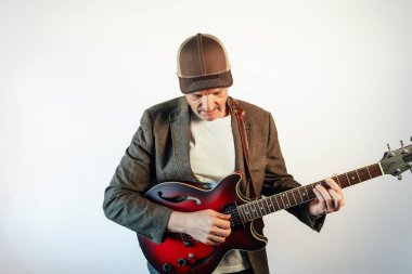 Gitar çalarken aşağı bakan bir adam