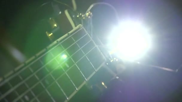 Man spelar elektrisk gitarr stag ljus bakgrund — Stockvideo
