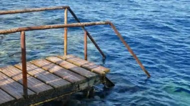 Deniz kıyısı mavi şeffaf su yüzeyi ile köprüde