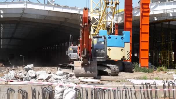 Bagger, Baukran und Arbeiter auf der Baustelle — Stockvideo