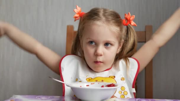 Funny little girl shows her fingers like a cows horns on kitchen — Stock Video