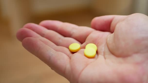 Person pouring bunch of prescription yellow opiate pills into hand — Stock Video