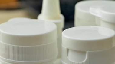 İçinde ilaç ya da hap olan beyaz plastik şişe.
