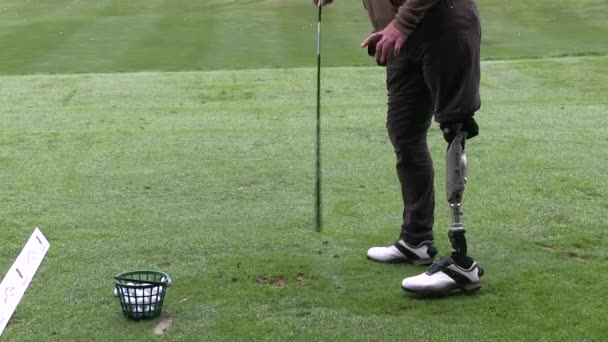 Pessoa com deficiência com perna protética jogando golfe — Vídeo de Stock