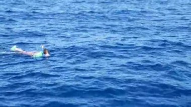 Kadın deniz mavi suda yüzüyor