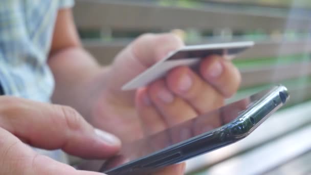 Hombre comprar en línea con teléfono inteligente rojo y tarjeta de crédito — Vídeo de stock