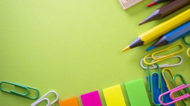 İleti örneği arka planı yeşil üzerinde. Kalem, kurşun kalem, makas, ataç, renkli itme pins ve masanın üzerinde. Yukarıdan kopya alanı ile göster